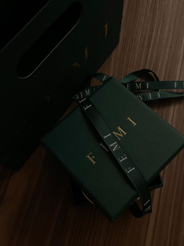 Luxurious dark green gift box with ribbon on a wooden surface, perfect for special occasions.